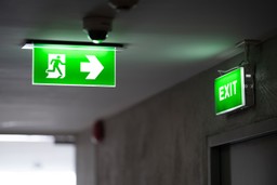 A clear and visible emergency exit sign in a hallway.